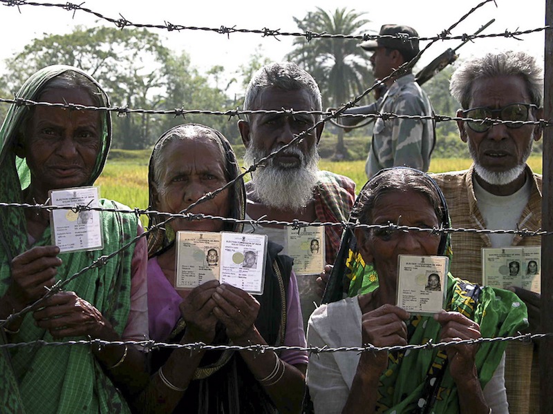 Indians standing outside of the International Barbed Wire Border Fence