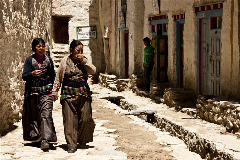 Traditionally dressed women walk pass inside the walled city of Lo Manthang, Upper Mustang