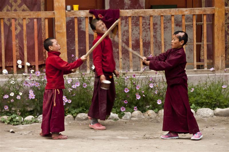 Young monks play with wooden sticks inside the monastery complex in Lo Manthang.