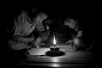 Burmese immigrants Thailand farms labourers writing by candlelight
